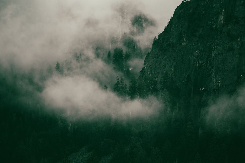 Atmospheric scene of a misty mountain enveloped in dense fog, creating a mysterious and moody ambiance.